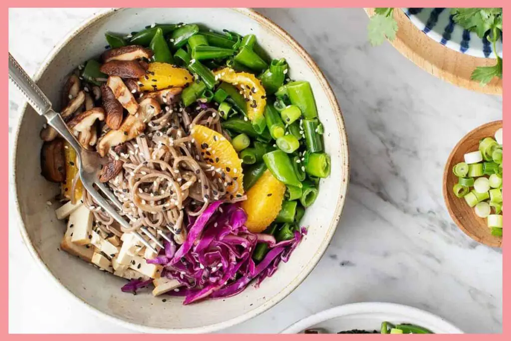 A picture of 15-Minute Meal Prep Sesame Noodle Bowls in a white deep plate and a silver spoon inside