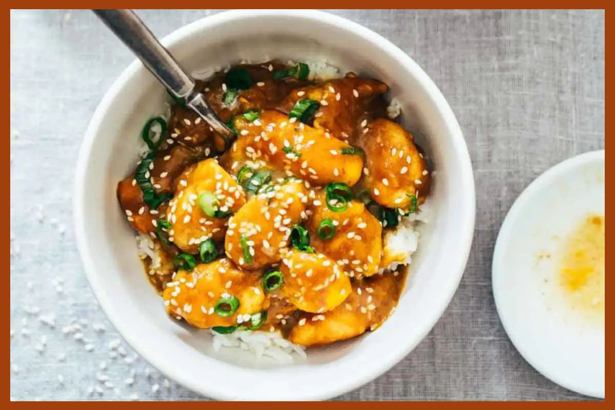 A picture of 30-Minute Sesame Mango Chicken Teriyaki in a white plate with a silver spoon in it.