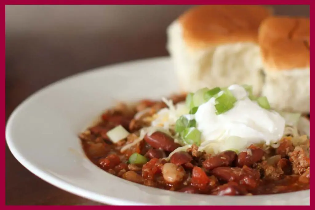 A picture of 30-Minute Spicy Ancho Turkey Chili and bread on a white flat plate.