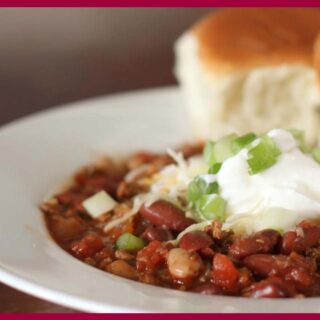 A picture of 30-Minute Spicy Ancho Turkey Chili and bread on a white flat plate.