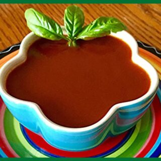 A picture of 5-Minute Blender Enchilada Sauce in a blue bowl. The bowl is placed on a flat plate.
