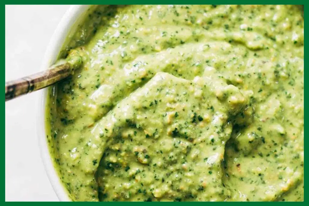 A picture of 5-Minute Homemade magic green sauce with a metal spoon in a white bowl