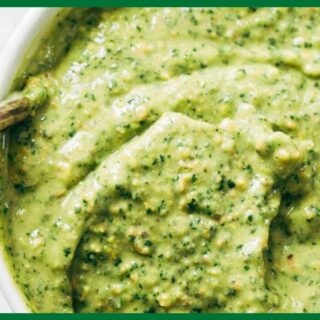 A picture of 5-Minute Homemade magic green sauce with a metal spoon in a white bowl