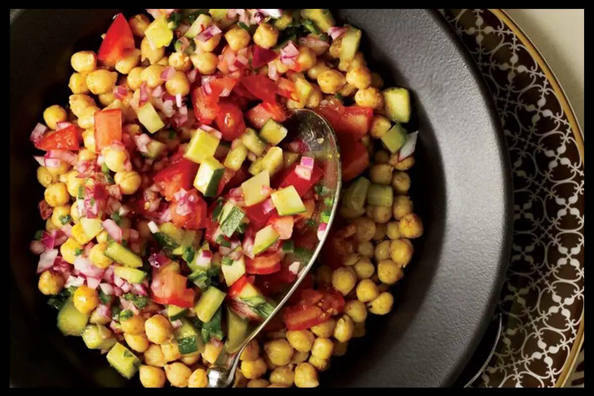 A picture of 5-Minute Spicy Chickpea Salad in a black plate with a spoon in it.