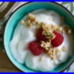 A picture of 5-Minute Vegan Yogurt in a blue plate with raspberry and oat on top.