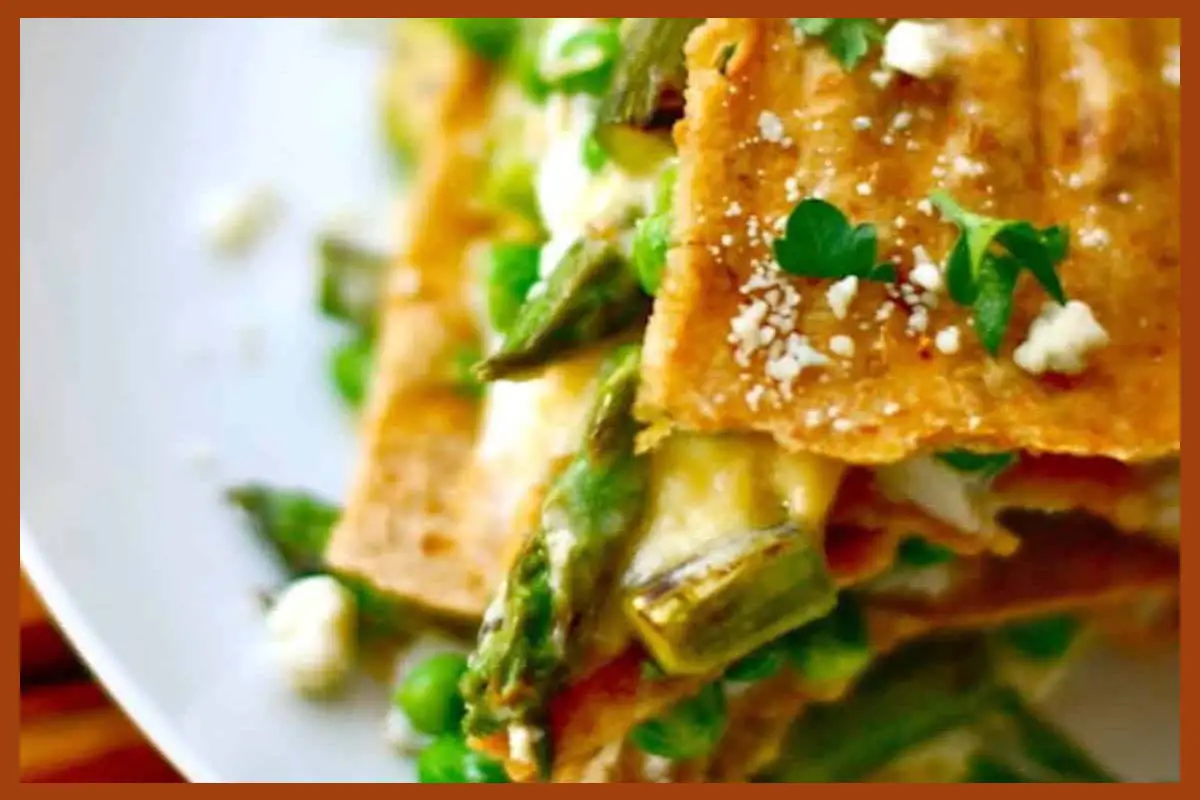 A picture of Delicious looking Asparagus Quesadilla Lasagna on a white flat plate.