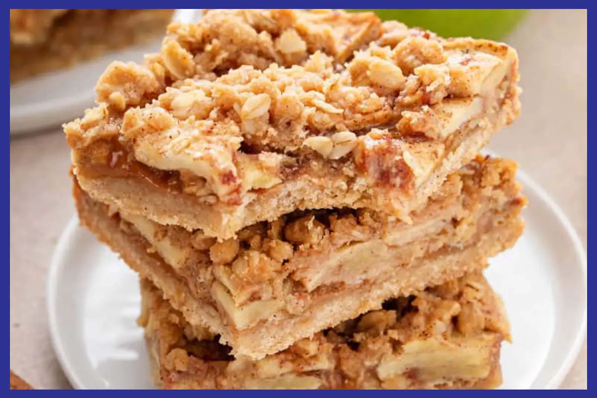 A picture of 3 Caramel Apple Crisp Bars stacked on top of each other on a white place