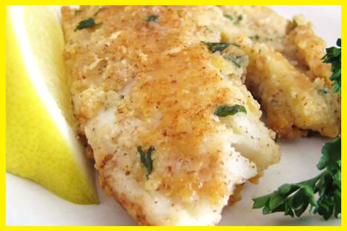A picture of Almond Crusted Tilapia with lemon beside it on a white plate