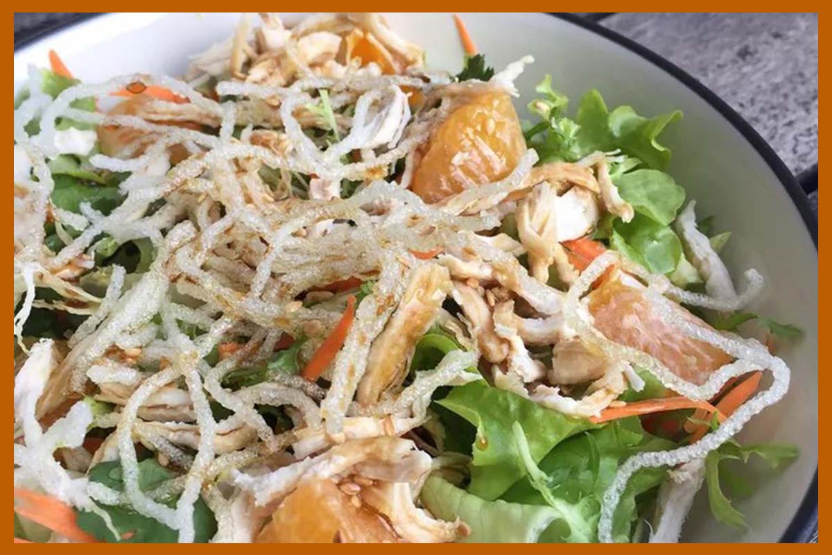 A picture of Asian Chicken Salad in a white bowl.