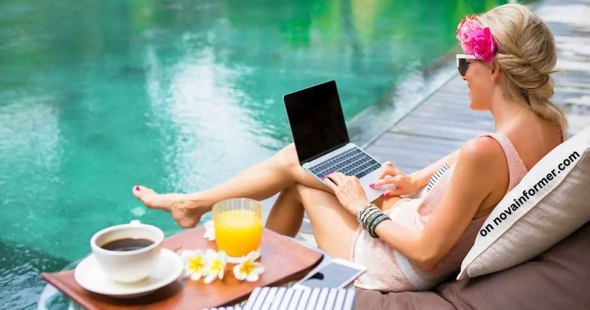 A woman relaxing by a beautiful pool or body of water with her laptop on her laps